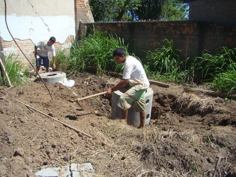 canteiro-de-obra-comeca-a-ser-levantado-1 Homens instalam uma fossa em frente ao galpão onde ficará o escritório.