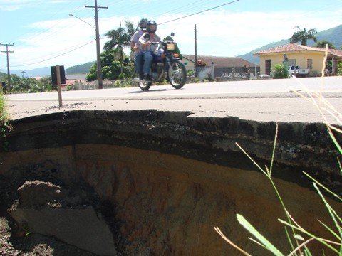 cuidado-com-as-crateras-1 Buracão na SC-438, em Braço do Norte, fica em uma curva. Um perigo para um motorista desavisado que precise usar o acostamento.