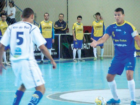 hipper-freios-unisul-perde-mais-uma-1 Wender (com a bola) fez o terceiro gol da Hipper Freios/Unisul ontem. Mas não foi o suficiente para bater o Rio do Sul.