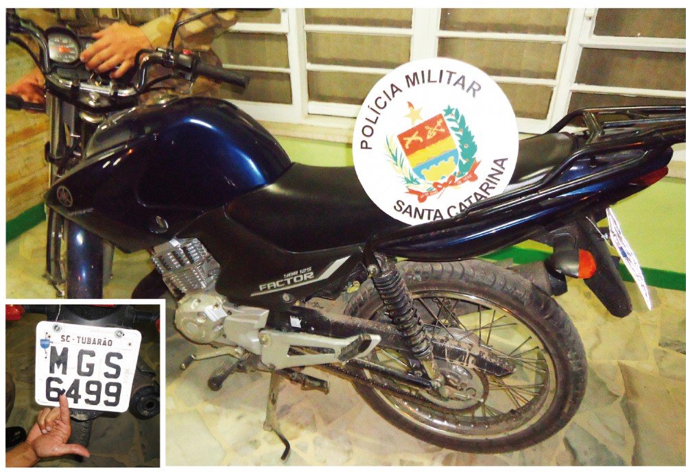 dupla-e-detida-minutos-apos-assalto-a-posto-1 A motocicleta usada pela dupla no assalto possuía registro de furto. Na foto em detalhe, o policial militar mostra o pedaço de fita que estava colocado para adulterar a placa - Foto:Fotos: Polícia Militar de Tubarão/Notisul