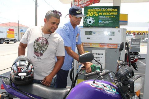 a-pe-de-bike-ou-de-onibus-e-agora-1 O entregador Rafael Martins abastece a sua moto semanalmente