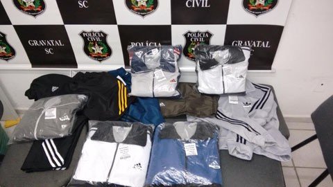 roupas-e-etiquetas-falsificadas-sao-apreendidas-1 Além dos policiais localizarem as roupas na loja, na fábrica também havia várias peças falsificadas em produção - Foto:Polícia Militar de Gravatal/Divulgação/Notisul