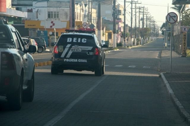 deic-camara-operacao-seival-2-b #Pracegover Foto: Na imagem há dois carros pretos da polícia civil nas ruas de Laguna pela manhã