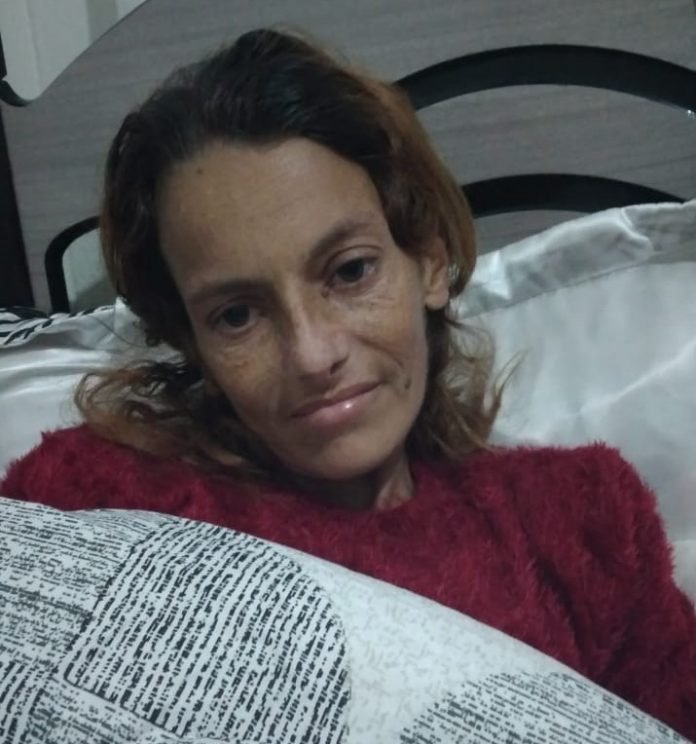 moradora #Pracegover Foto: Na imagem há uma mulher em uma cama, com roupas de inverno e com cobertor