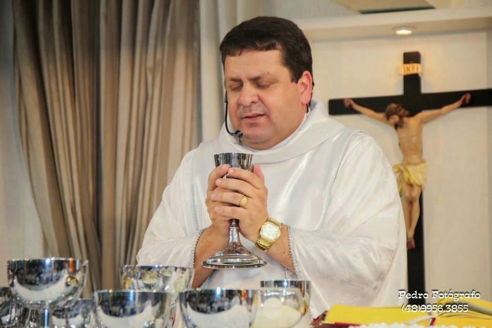 avelino-1 #Pracegover Foto: na imagem há um padre, em suas mãos um cibório e sobre o altar alguns cibórios e na parede um crucifixo