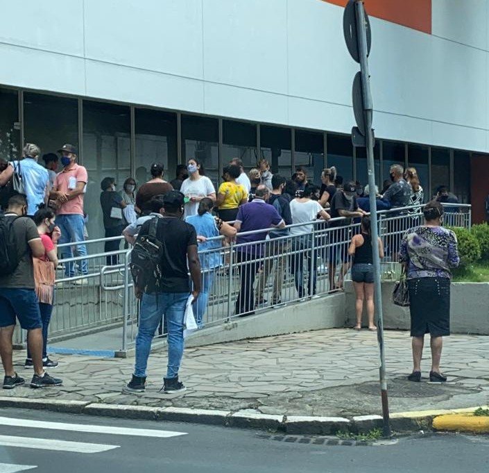 banco #Pracegover Foto: na imagem há muitas pessoas próximas em uma fila de banco, no centro de Tubarão