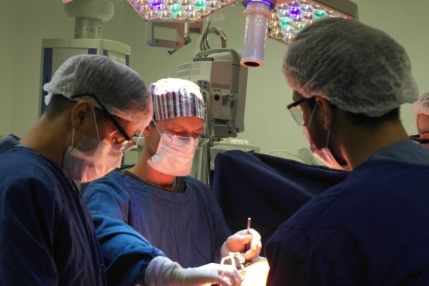 cirurgia_hospital_medico_procedimento #Pracegover Foto: na imagem há três profissionais de saúde realizando um procedimento cirurgico