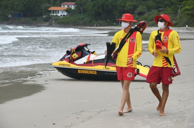 guarda-vidas #PracegoverFoto: na imagem há dois homens, areia e mar