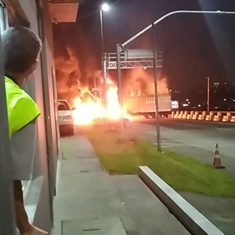 #Pracegover Foto: na imagem há um homem observando o fogo em um veículo