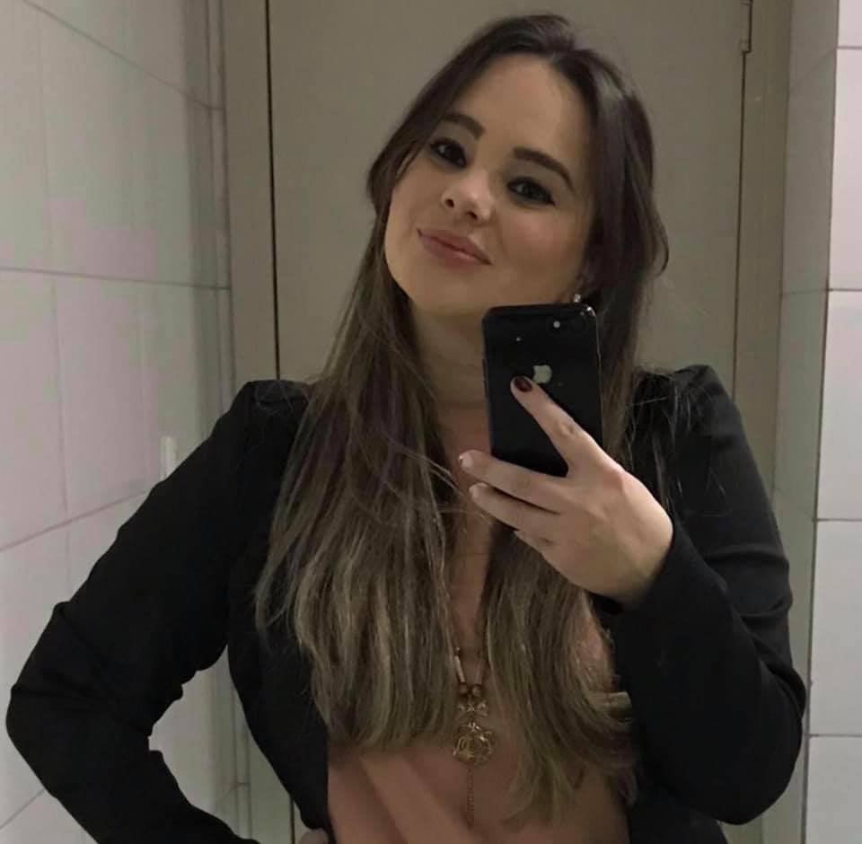 Pamela #Pracegover Foto: na imagem há uma mulher de cabelos compridos, roupa rosa e preto e com um celular na mão