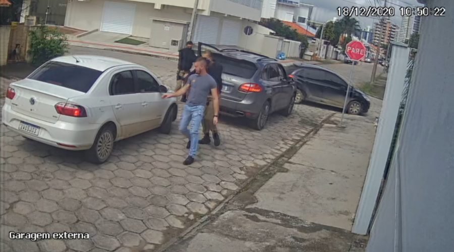 vitima #Pracegover Foto: na imagem há três pessoas, carros e casas