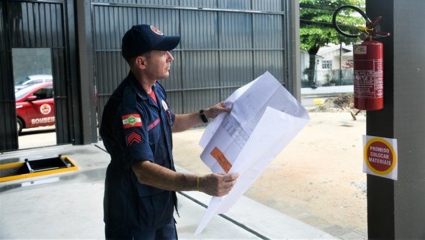 Após 8 anos da tragédia na Boate Kiss, Bombeiros de SC apostam no desenvolvimento de tecnologias em prevenção #Pracegover Na foto, a imagem de um bombeiro com um papel na mão