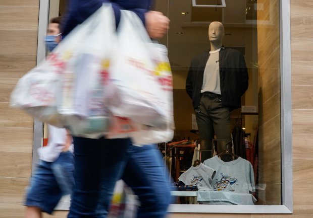 comercio #Pracegover Foto: na imagem há manequim e duas pessoas com sacolas nas mãos