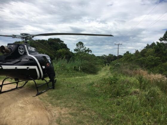 Dic #Pracegover Foto: na imagem há um homem,um helicóptero e mata