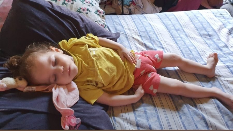 menina #Pracegover Foto: na imagem há uma criança dormindo em uma cama