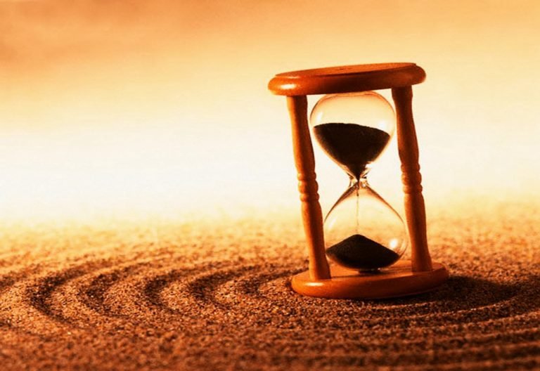 #Pracegover Foto: na imagem há uma ampulheta no deserto