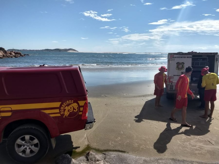 afogamento #Pracegover Foto: na imagem há um veículo do Corpo de Bombeiros, um veículo do IML, três homens, o mar e a faixa de areia