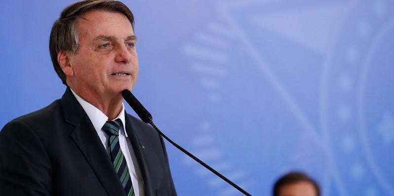 Bolsonaro #Pracegover Foto: na imagem há um homem de terno e um microfone
