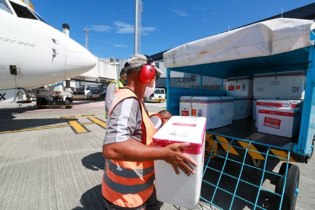 caixas #Pracegover Foto: na imagem há uma aeronave, um homem e algumas caixas de isopor
