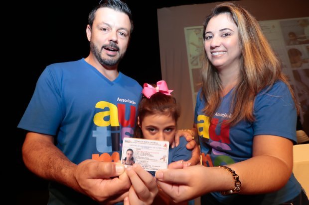 carteira de autista #Pracegover Foto: na imagem há três pessoas. Uma criança, um homem e uma mulher