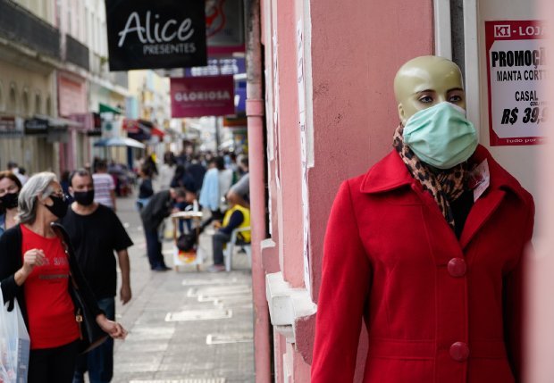comercio #Pracegover Foto: na imagem há um manequim e muitas pessoas nas ruas