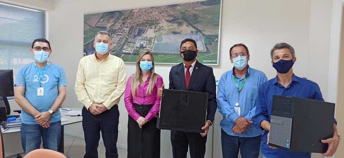 computadores #Pracegover Foto: na imagem há cinco homens e uma mulher, um quadro e equipamentos de informática
