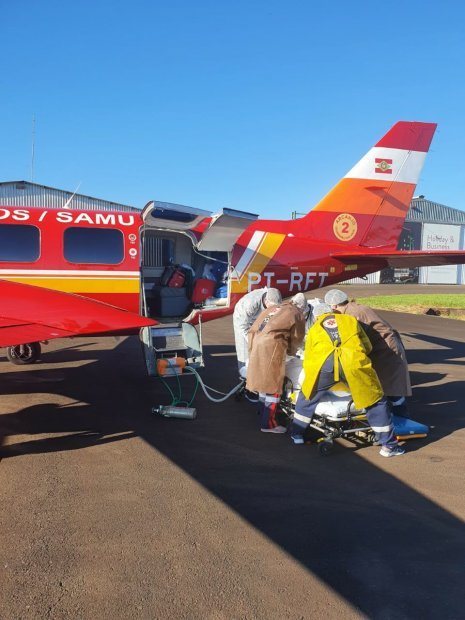 Covid-19 Governo de SC transfere pacientes do Oeste para outras regiões do Estado #Pracegover Na foto, Bombeiros preparam pacientes antes da transferência feita pela aeronave