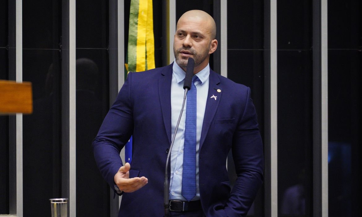 deputado #Pracegover Foto na imagem há um homem de terno e um microfone