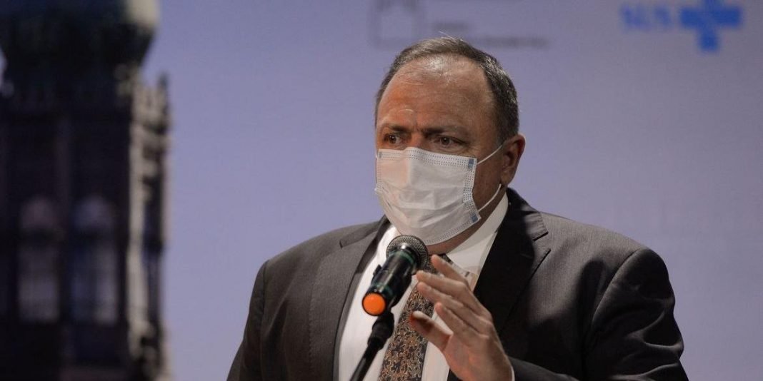 Pazuello #Pracegover Fot: na imagem há um homem de terno preto, camisa branca e de máscara. Há também um microfone