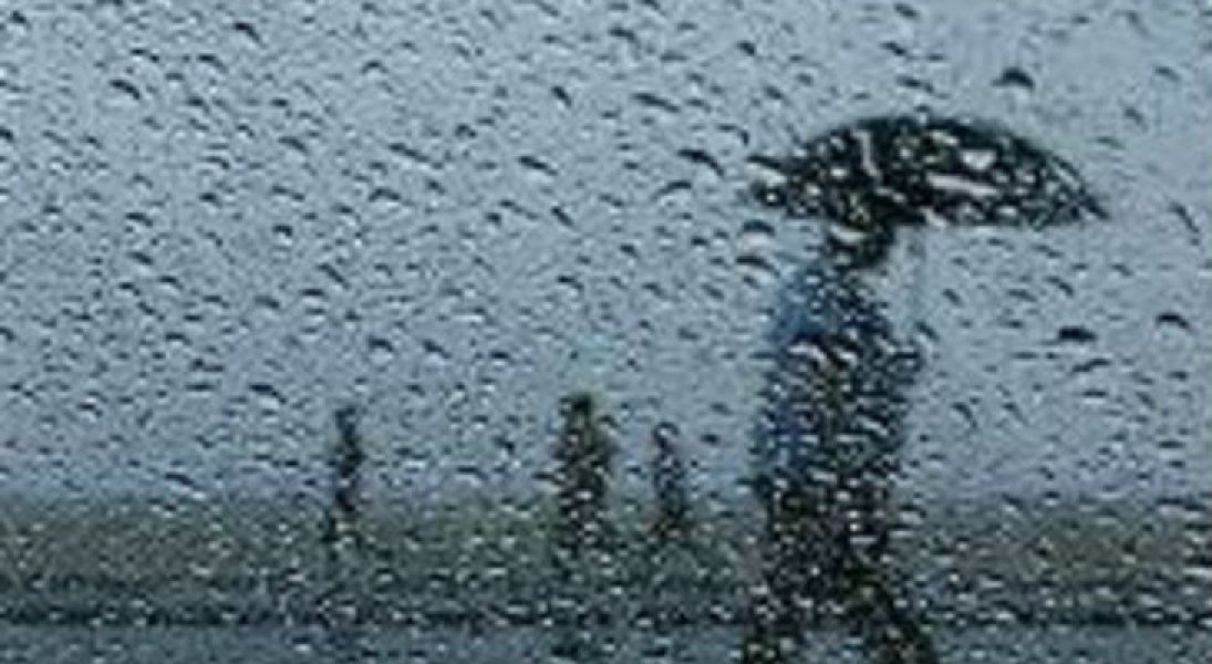 Quinta-feira será de pancadas de chuvas dos Planaltos ao Litoral de Santa Catarina #pracegover Na foto, pingos de chuva em um vidro e ao fundo silhueta de pessoas caminhando com guarda-chuva