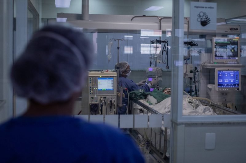 corona #Pracegover Foto: na imagem há profissionais de saúde cuidando de um paciente na UTI
