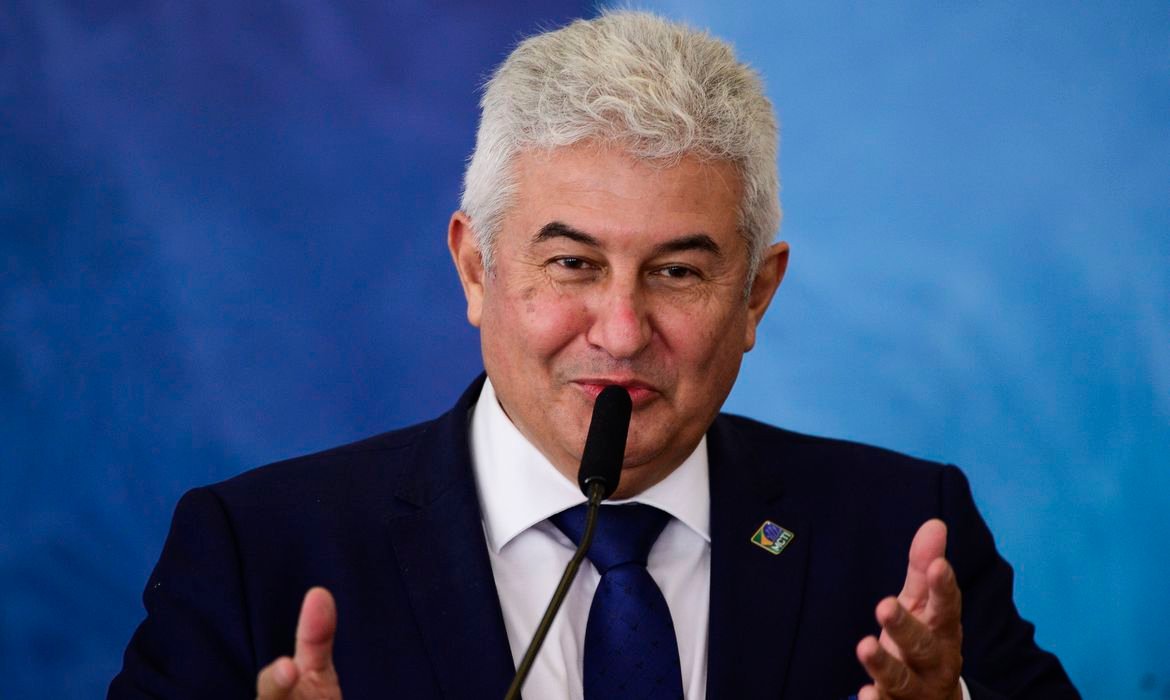 marcos #Pracegover Foto: na imagem há um homem de terno, com cabelo grisalho e um microfone