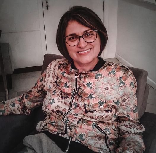 professora Elíria #Pracegover foto: na imagem há uma mulher com a roupa estampada, de óculos e sorridente