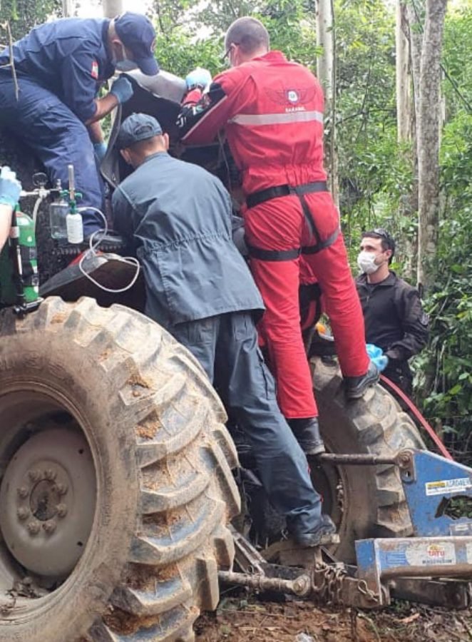 resgate #Pracegover Foto na imagem há quatro homens, um trator e árvores