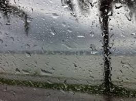#Pracegover Na foto, pingos de chuva na janela de um carro deixam a paisagem ao fundo desfocada: o mar e árvores