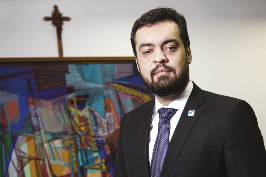 governador do rj #Pracegover Foto: na imagem há um homem de terno, um quadro e um crucifixo