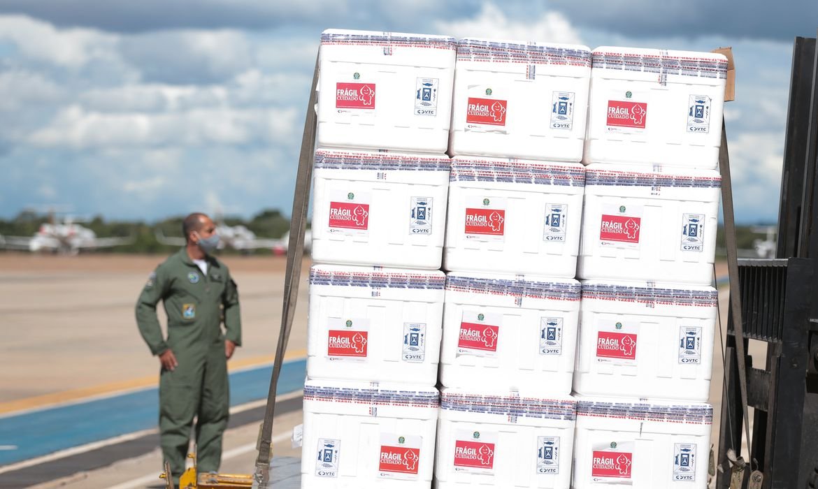 Ministério da Saúde anuncia vacinação de portuários e aeroviários #Pracegover Na foto, aeroviário manuseando caixas de vacina