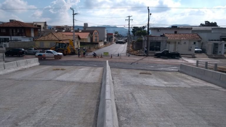 #Pracegover Foto: na imagem há uma ponte, máquina, casas e ruas