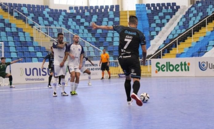 tb-futsal #Pracegover Foto: na imagem há atletas, uma quadra e arquibancadas