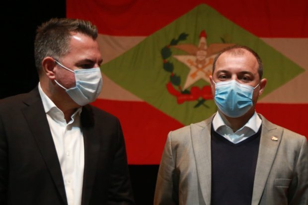 VIGILÂNCIA #Pracegover Foto: na imagem há dois homens de máscara e a bandeira de SC