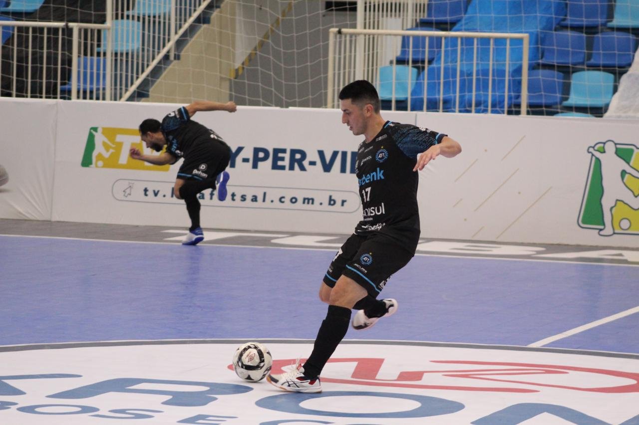 jogdores #Pracegover Foto: na imagem há dois homens, uma bola, uma quadra e arquibancada