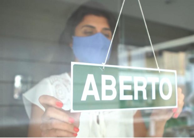 mulher #Pracegover Foto: na imagem há uma mulher, uma placa e uma vitrine