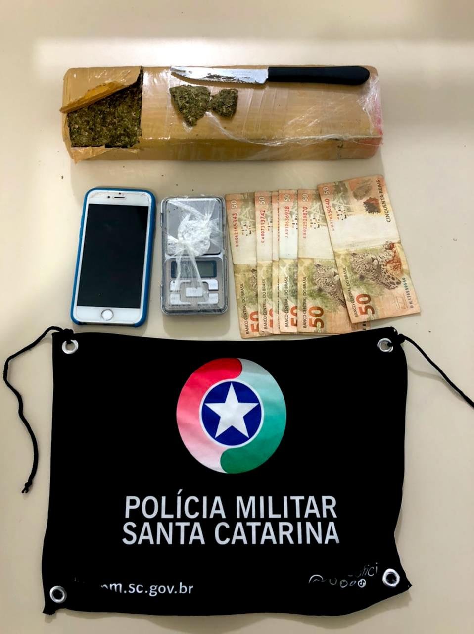 pm tb #Pracgover Foto: na imagem há cédulas em reais, celulares, uma faca e produto ilícito