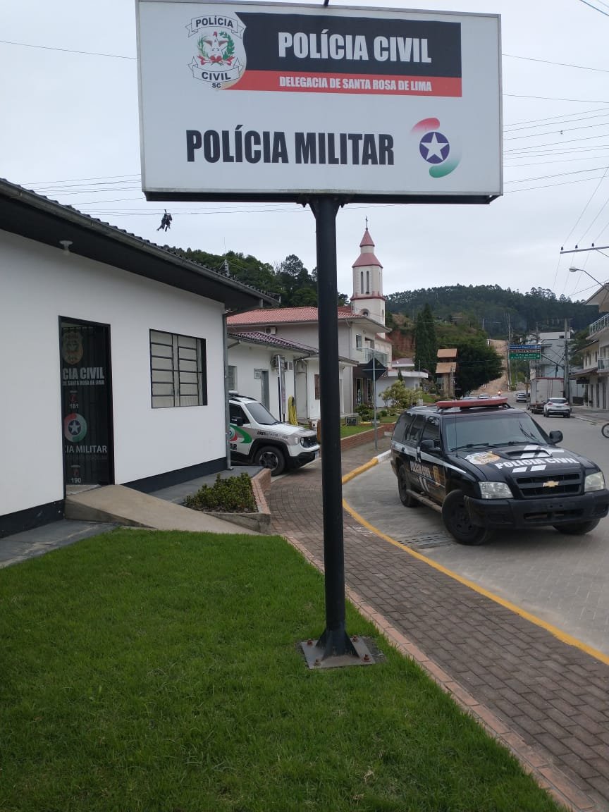 Policia #Pracegover Foto: na imagem há veículos, construções, via e placa