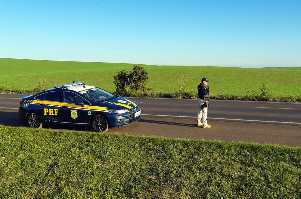 PRF inicia Operação Corpus Christi 2021 #Pracegover Na foto, viatura da PRF e um policial em uma rodovia federal