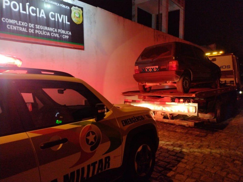 veiculo-furtado #Pracegover Foto: na imagem há um veículo em cima de um caminhão e uma viatura da PM