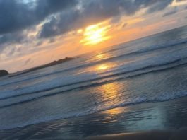 #Pracegover Na foto, nascer do sol no mar, céu parcialmente coberto de nuvens
