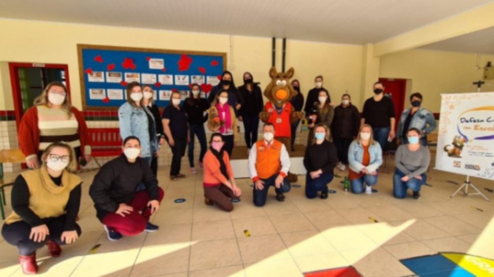 SC inclui proteção e defesa civil no currículo das escolas públicas e privadas #Pracegover Na foto, pessoas reunidas em um galpão