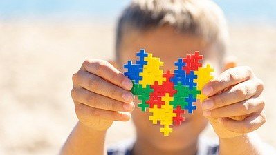 Criança com autismo de São Ludgero tem direito a terapia ocupacional pelo SUS #Pracegover Na foto, criança segurando um coração feito com peças coloridas