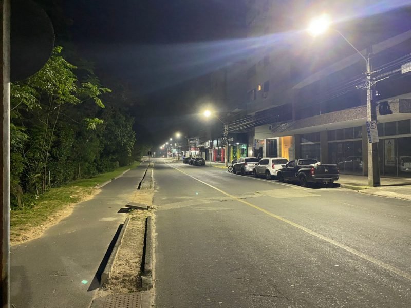 lampadas #Pracegover foto: na imagem há uma voa, carros, árvores, construções e postes com iluminação